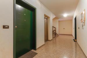 a hallway with a green door in a building at La casetta in Castel Maggiore