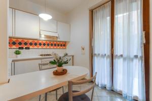 a kitchen with a white table and chairs and a window at La casetta in Castel Maggiore +16 photos