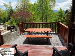 a wooden deck with a picnic table and two chairs at Black Bear Tracks in Gatlinburg