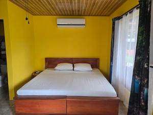 a yellow bedroom with a bed in a room at Rusticas Dani in Tanque +24 photos