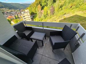 a balcony with two chairs and two tables and a view at Ferienwohnung Ausblick in Bad Wildbad