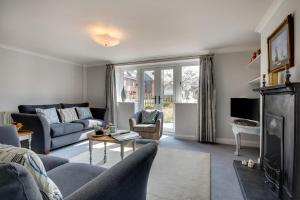 een woonkamer met een bank en een tafel bij Garden Cottage in Holt