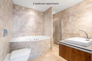 a bathroom with a tub and a toilet and a sink at Ersfjord Villa Apt in Tromsø +56 photos