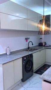 een keuken met een wasmachine onder een aanrecht bij 3 bedroom apartment, Ikate in Lekki