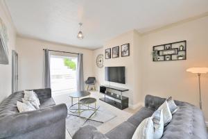 Una sala de estar con un sofá y un televisor. en Sleek and Stylish 3 Bed in Bolton-Garden-Parking, en Bradshaw