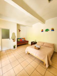 a bedroom with a bed and a couch at Habitaciones Casa Bule in Oaxaca City
