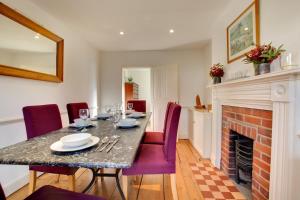 una sala da pranzo con tavolo e camino di Holly Cottage a Cromer