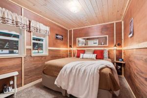 a bedroom with a bed in a room with wooden walls at Sugar Pine cabin in the woods King bed Fire pit in Oakhurst