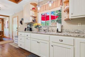 a kitchen with white cabinets and a window at Sugar Pine cabin in the woods King bed Fire pit in Oakhurst