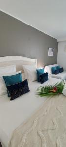a large white bed with pillows on top of it at Studio Luxe vue mer in Le Gosier