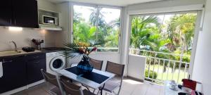 a kitchen with a table with a vase on it at Studio Luxe vue mer in Le Gosier