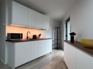 a kitchen with white cabinets and a microwave at NEU - Apartment in Brühl-City in Brühl