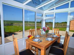 a dining room with a table and chairs and windows at 3 Bed in Hartland GLAKE in Hartland