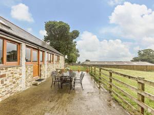 un patio con tavolo e sedie accanto a un fienile di 3 Bed in Launceston 57287 a Launceston