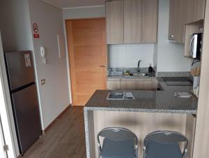 a kitchen with a counter and two chairs in it at Vanguardia 924 in Temuco +17 photos