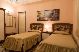 a room with two beds and a painting on the wall at B&B Palazzo Mantegna in Gioiosa Ionica