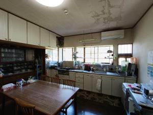 a kitchen with a wooden table and a wooden table and a tableablish at Echizen Guest House TAMADA - Vacation STAY 03847v in Sakai