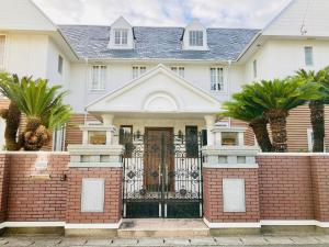 a white house with a gate and palm trees at sunset hills - Vacation STAY 65095v in Hamada