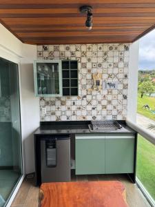 eine Küche mit Theke und gefliester Wand in der Unterkunft Villa Hípica Resort Gravatá - Apartamento 701 in Gravatá