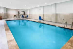 ein großes Schwimmbecken mit blauem Wasser in der Unterkunft Holiday Inn Express and Suites Houston North - IAH Area by IHG in Houston