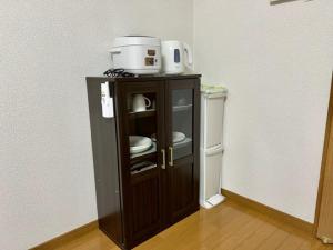 a small cabinet with a microwave on top of it at Blue Eyes Chuo - Vacation STAY 16693 in Kagoshima +1 photo