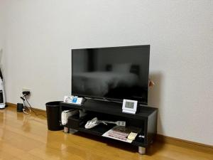 a flat screen tv sitting on a black entertainment center at Blue Eyes Chuo - Vacation STAY 16693 in Kagoshima
