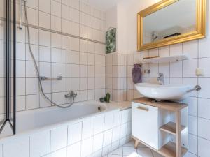 Un baño con lavabo, bañera y espejo. en Ferienhaus in Tönning, en Tönning 22 fotos más