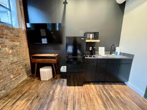 a kitchen with a black refrigerator and a wooden floor at The Produce Suites in Toledo