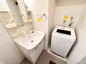 a small white bathroom with a sink and a sink at P,marks Arata - Vacation STAY 16694 in Kagoshima