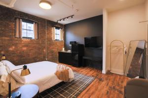 a bedroom with a bed and a brick wall at The Produce Suites in Toledo