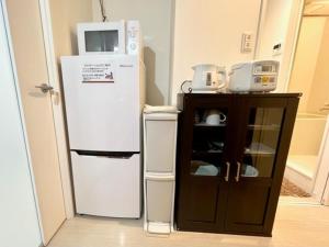 a kitchen with a refrigerator and a small cabinet at M,ULTRA - Vacation STAY 16696 in Kagoshima