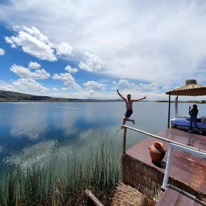 a man jumping off a dock into a lake at Titicaca amanecer in Puno +2 photos