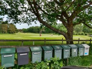 a row of green electrical boxes sitting next to a tree at 2 person holiday home in STRÖMSTAD-By Traum in Strömstad