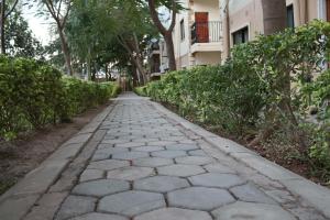 ルサカにあるThe Mallside Apartmentsの木の立つ建物前の石道