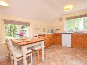 a kitchen with wooden cabinets and a table and chairs at 2 Bed in Ashburton 53519 in Bickington