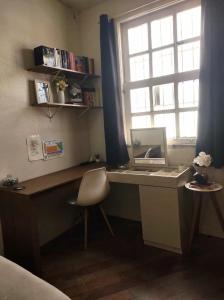 a desk with a mirror and a window in a room at casa santos cop 30 in Belém