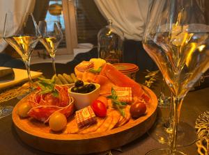 a plate of food on a table with wine glasses at Love Room - La clé des secrets - Gîte Romantique in Nuillé-le-Jalais