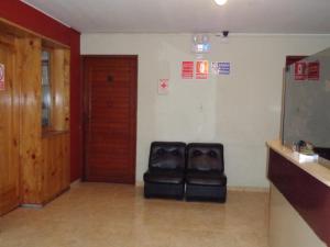 a chair sitting in a room with a door at Antares Inn in Lima