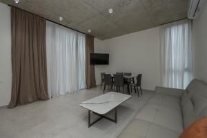 a living room with a couch and a table at 5 Star Duluxe Apartment in Villa Magnetica in Ozurgetʼi