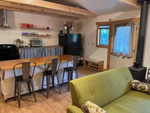 a kitchen and living room with a table and chairs at Still Point in the Woods in Ashland