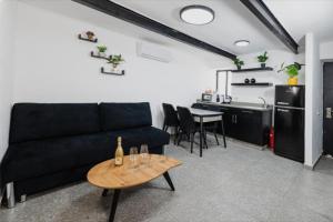ティベリアにあるRoyal Suites Tiberiasの黒いソファとテーブルのあるリビングルーム