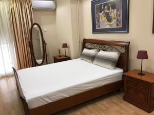 a bedroom with a large white bed with a mirror at Διαμέρισμα στο κέντρο της Θήβας in Thiva