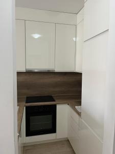 a kitchen with white cabinets and a microwave at Elly in Modriča