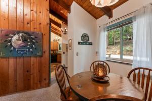 ein Esszimmer mit einem Holztisch und Stühlen in der Unterkunft Retro Retreat, BBQ, Patio with Outdoor Seating! in Lake Arrowhead