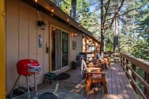 eine Veranda eines Hauses mit Stühlen und einem Grill in der Unterkunft Retro Retreat, BBQ, Patio with Outdoor Seating! in Lake Arrowhead
