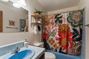 ein Badezimmer mit Waschbecken und Duschvorhang in der Unterkunft Retro Retreat, BBQ, Patio with Outdoor Seating! in Lake Arrowhead + 33 Fotos