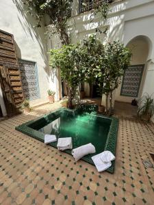 a swimming pool in a room with trees and towels at Luxury riad with swimming pool breakfast included in Marrakech