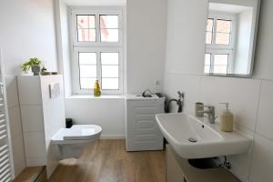 リューベックにあるCharmante 2-Zimmer-Wohnung am Wasser & Altstadtのトイレと洗面台を備えた白いバスルーム