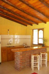 a kitchen with a sink and a counter with stools at Cabaña La Tranquera in San Rafael