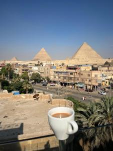 a cup of coffee on a balcony with pyramids at Continental de las pirámides in Cairo